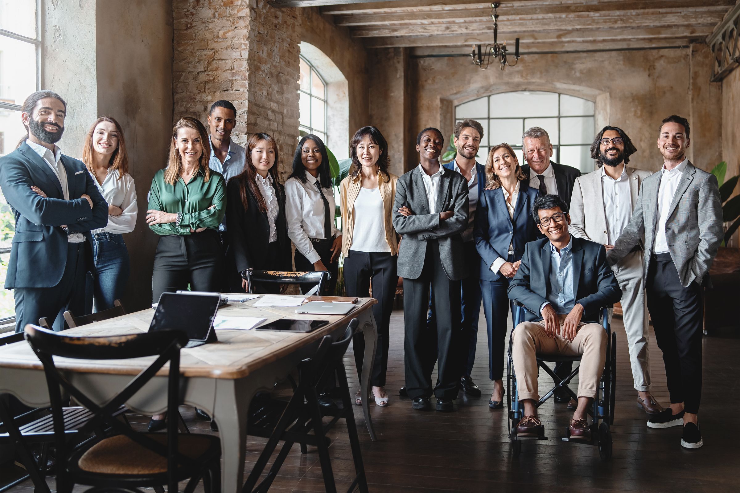 A mixed team of colleagues smiling together in a bright loft office